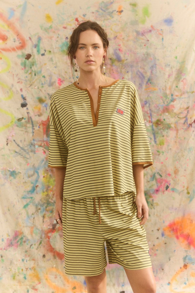 Woman wearing a yellow and green striped outfit.