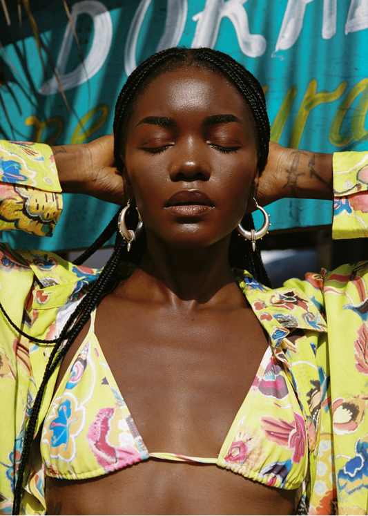 Woman wearing a colorful yellow floral bikini with a vibrant background