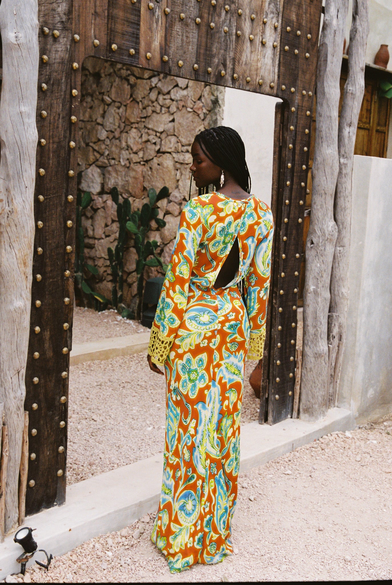 Woman wearing a colorful orange, blue and green patterned dress with lime green embroided contrast trim detail