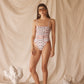 Woman in pink patterned one-piece swimsuit