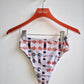 Pink floral-patterned high-waisted bikini bottom on a hanger against a white background