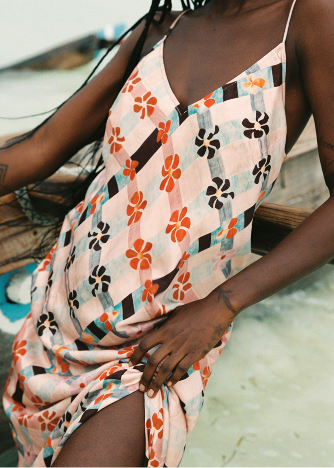Person wearing a pink floral dress with a blurred background