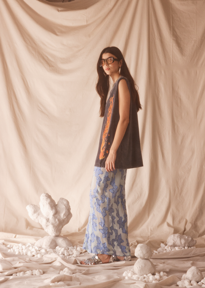 Woman standing in a studio with black tank with flame graphics