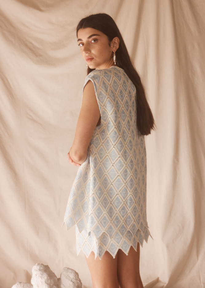 Woman wearing a light blue patterned set against a beige background