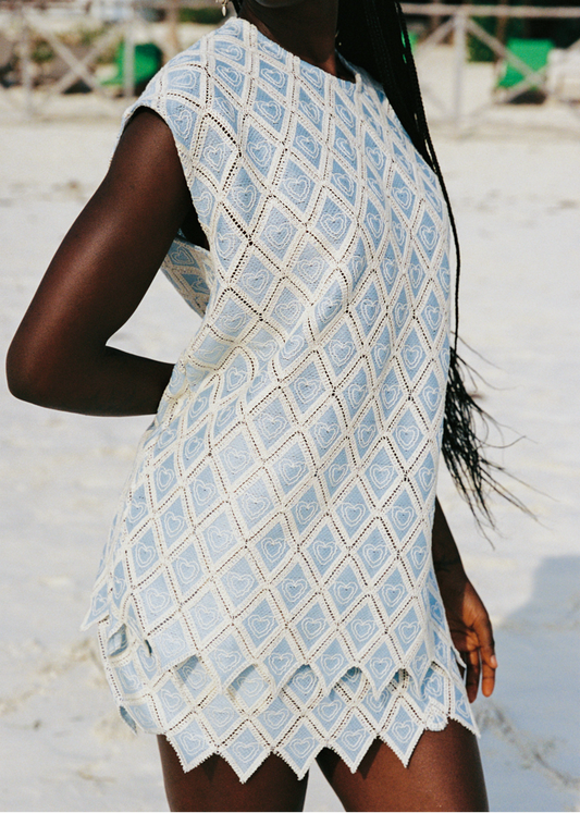 Person wearing a light blue patterned set on a beach.