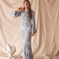 Woman wearing semi-sheer blue maxi with gold lurex florals, flared sleeves, and contrast piping.