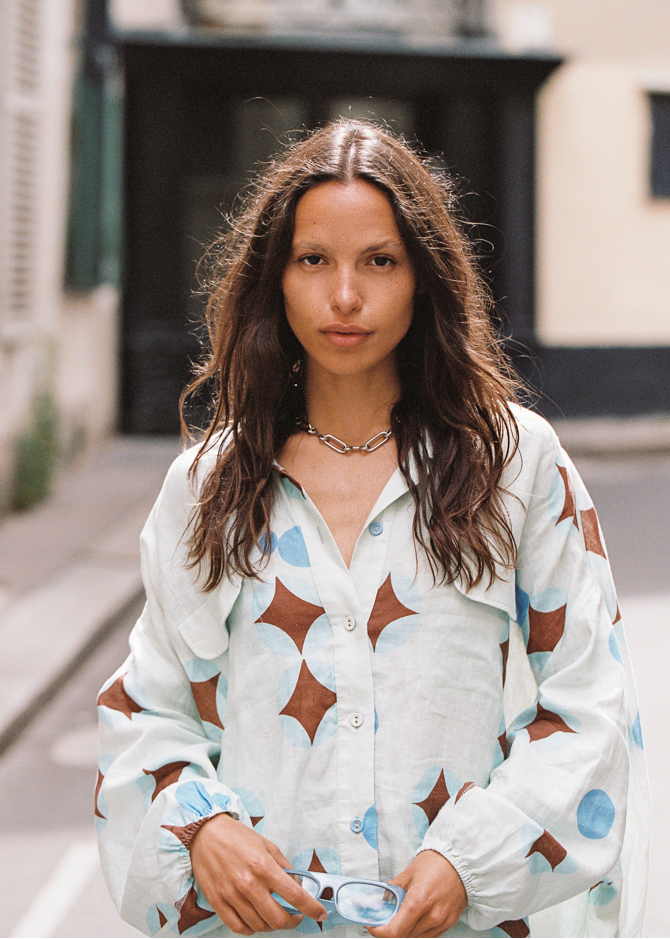 Model wearing Kinga Csilla Aquarius Chalm Shirt in baby blue linen with celestial brown and blue print, street style front view