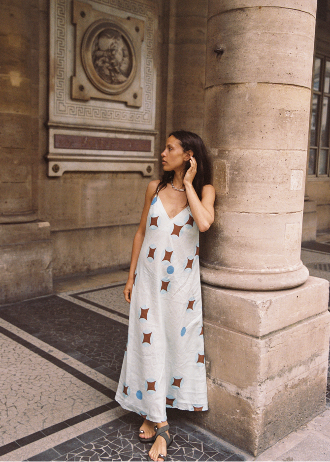 Model wearing Kinga Csilla Aquarius Sia slip dress, maxi length linen with celestial print, side view
