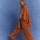 Model walking in Kinga Csilla Bello Swirl Jessi Pant with matching Bello Swirl Cup Shirt Dress in burnt orange with white embroidery, showing wide leg movement and relaxed fit
