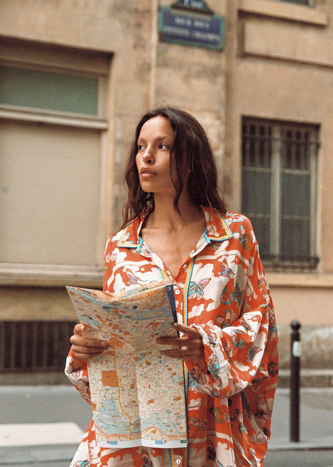 Kinga Csilla Farfalla Chalm Shirt in orange butterfly print, oversized long sleeve button-up shirt styled with city map for summer street style