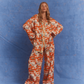 Kinga Csilla Farfalla Jessi Pant – relaxed wide-leg orange butterfly print pant with elasticated waist and silky drape, styled with the matching Farfalla Chalm Shirt, women’s statement fashion set on blue backdrop.
