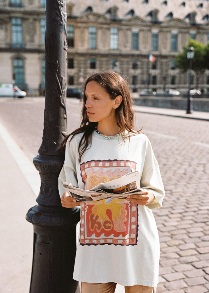 Model wearing Kinga Csilla HIBISCUS TEE, oversized cotton tee with vintage-stamp hibiscus motif, Paris street style look