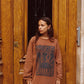 Model wearing Kinga Csilla Lino Roses Tee in brown, oversized long sleeve with vintage lino graphic, styled with Tottori Lace Ode Skirt in front of door.