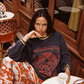 Close-up of the Kinga Csilla Love Potion Roses Tee in stonewashed black oversized long sleeve, styled with Farfalla Pants, Parisian café scene. Ethical bohemian style.