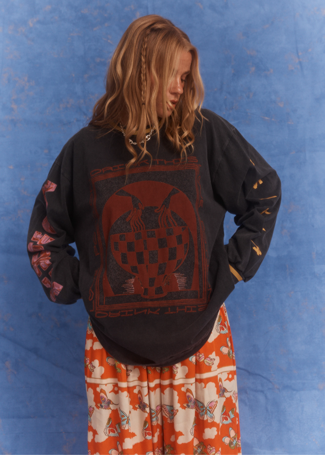 Model wearing Kinga Csilla Love Potion Roses Tee in stonewashed black with mystical rose artwork, styled with relaxed fit and long sleeves.