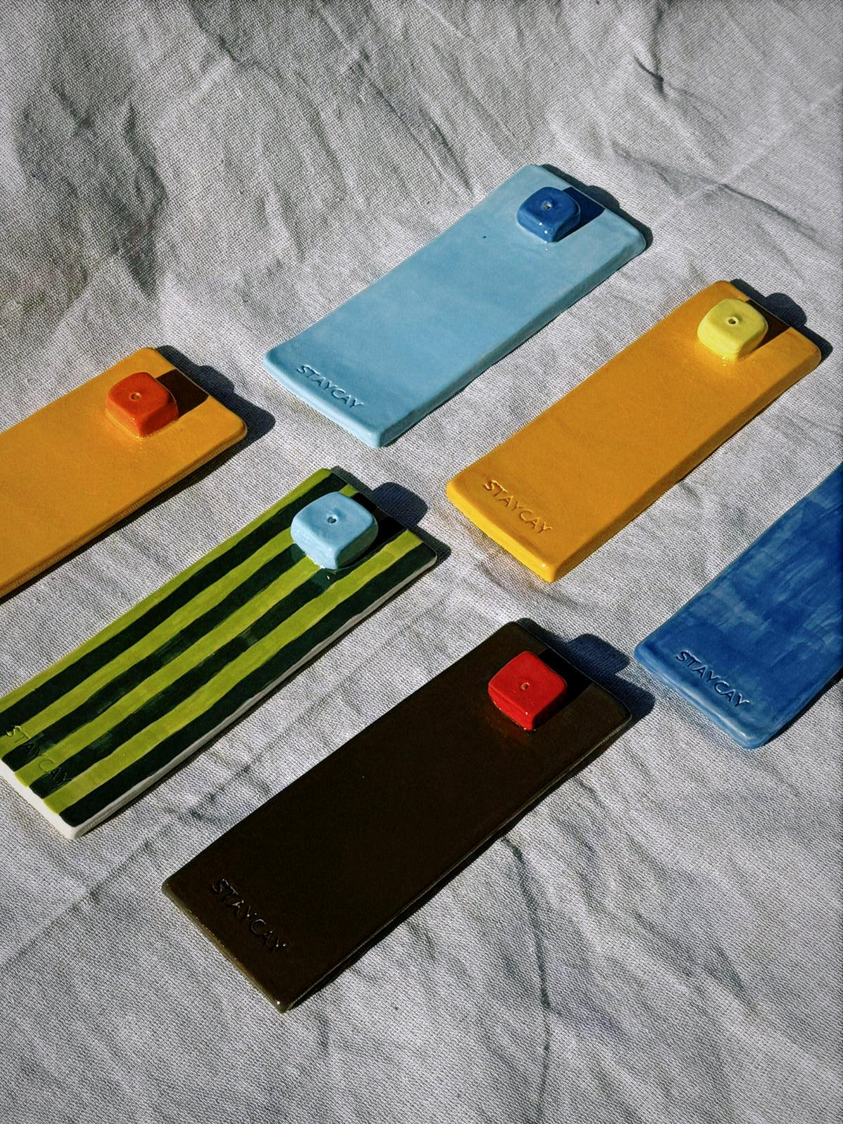 Kinga Csilla x Staycay ceramic incense holders handmade in Northern NSW, available in Green Stripe/Sky Blue, Brown/Red, Orange/Red, Orange/Yellow, Dark Blue/Sky Blue, and Sky Blue/Dark Blue colourways, glossy bohemian home décor for incense and aromatherapy.