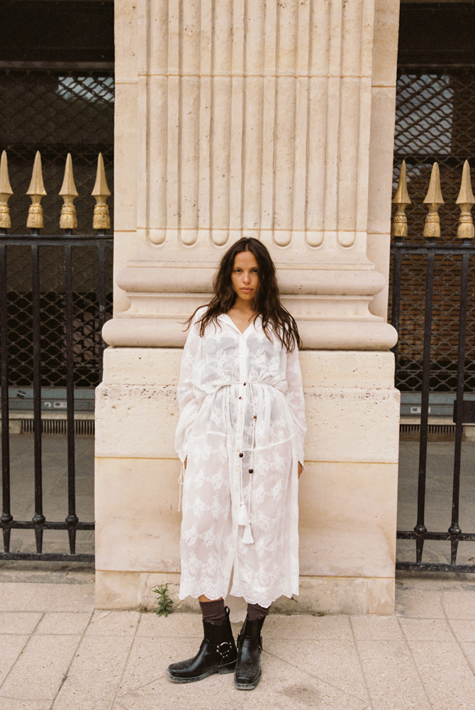 Model wearing the Kinga Csilla Tottori Lace Harlow Maxi white maxi dress, sheer cotton embroidery with adjustable drawstring cuffs and relaxed fit.