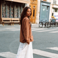 Model wearing Kinga Csilla Tottori Lace Ode Skirt, a white lace cotton maxi skirt, styled with oversized brown Lino Roses long sleeve tee in Paris street style look