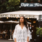Woman in Kinga Csilla Tottori Lace Pia Mini white lace dress walking in front of Café de Flore in Paris, effortless French summer outfit inspiration.