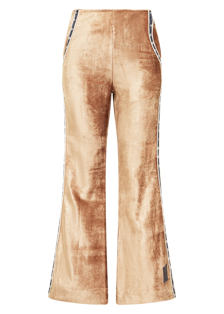 Kinga Csilla Twilight Velvet Flare Pant in golden stretch velvet, featuring high-rise waist, flared leg, contrast piping, and side pocket detail.