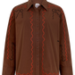 A brown long-sleeve button-up shirt with orange and black wavy line embroidery on the front and shoulders, displayed on a clean white background.