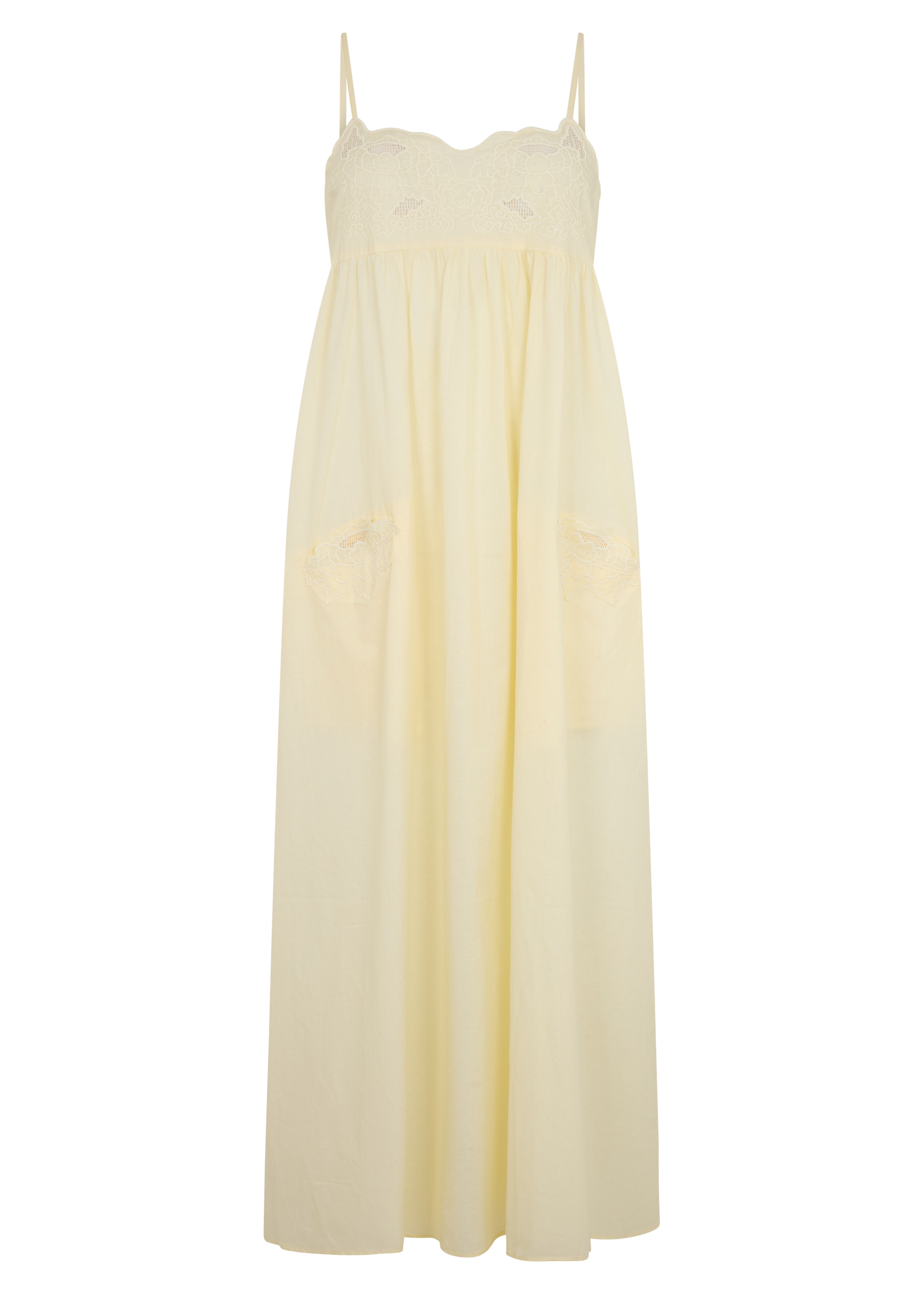 A pale cream maxi dress with thin spaghetti straps, a scalloped lace bodice, and two large patch pockets on a plain white background.