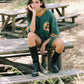 Woman sitting on a wooden bench in a park-like setting