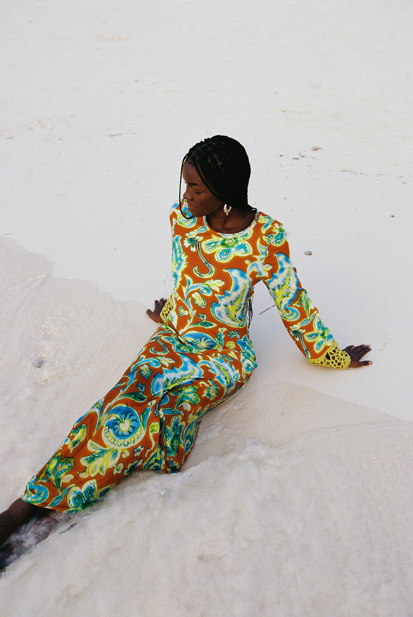Woman wearing a colorful orange, blue and green patterned dress with lime green embroided contrast trim detail