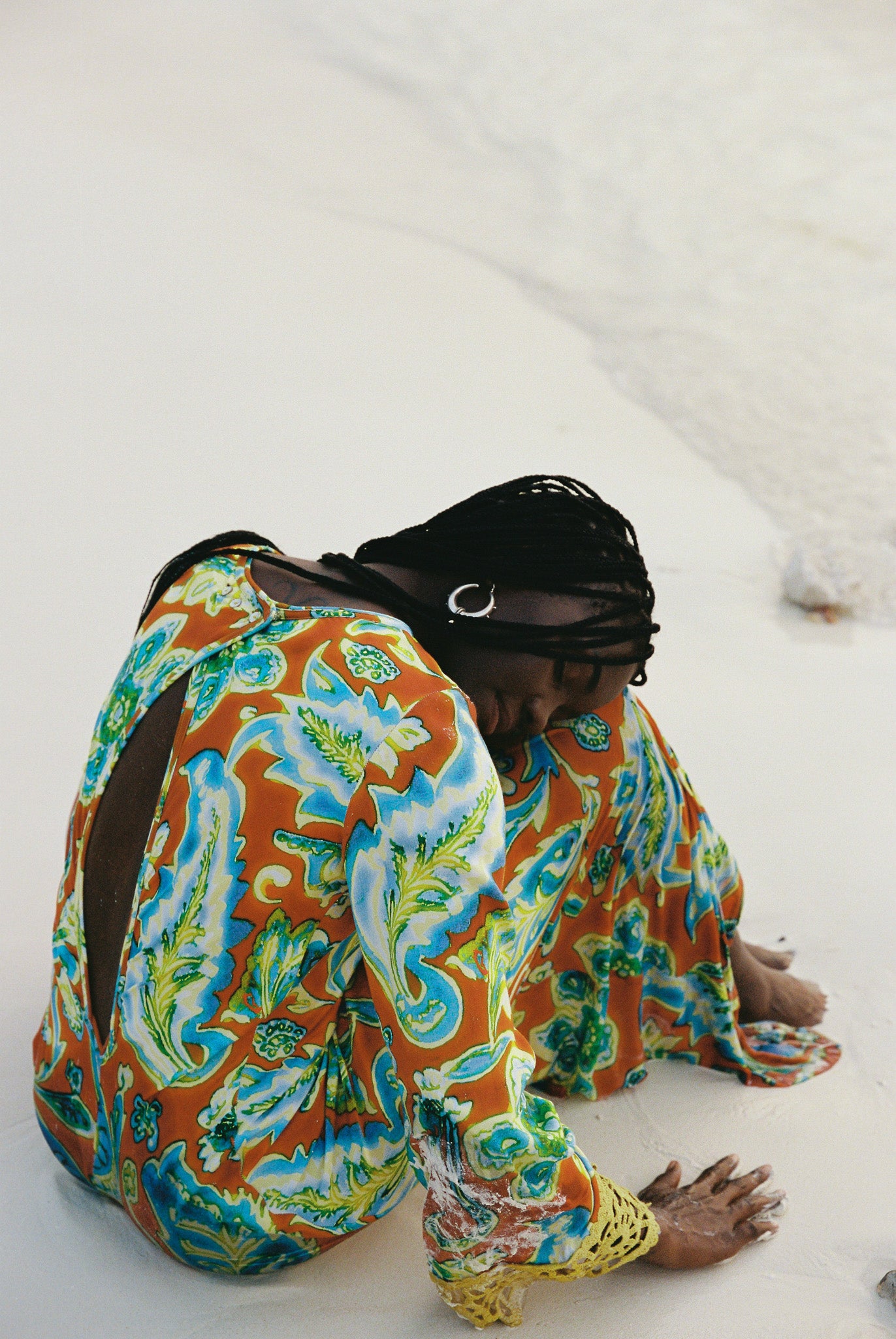 Woman wearing a colorful orange, blue and green patterned dress with lime green embroided contrast trim detail