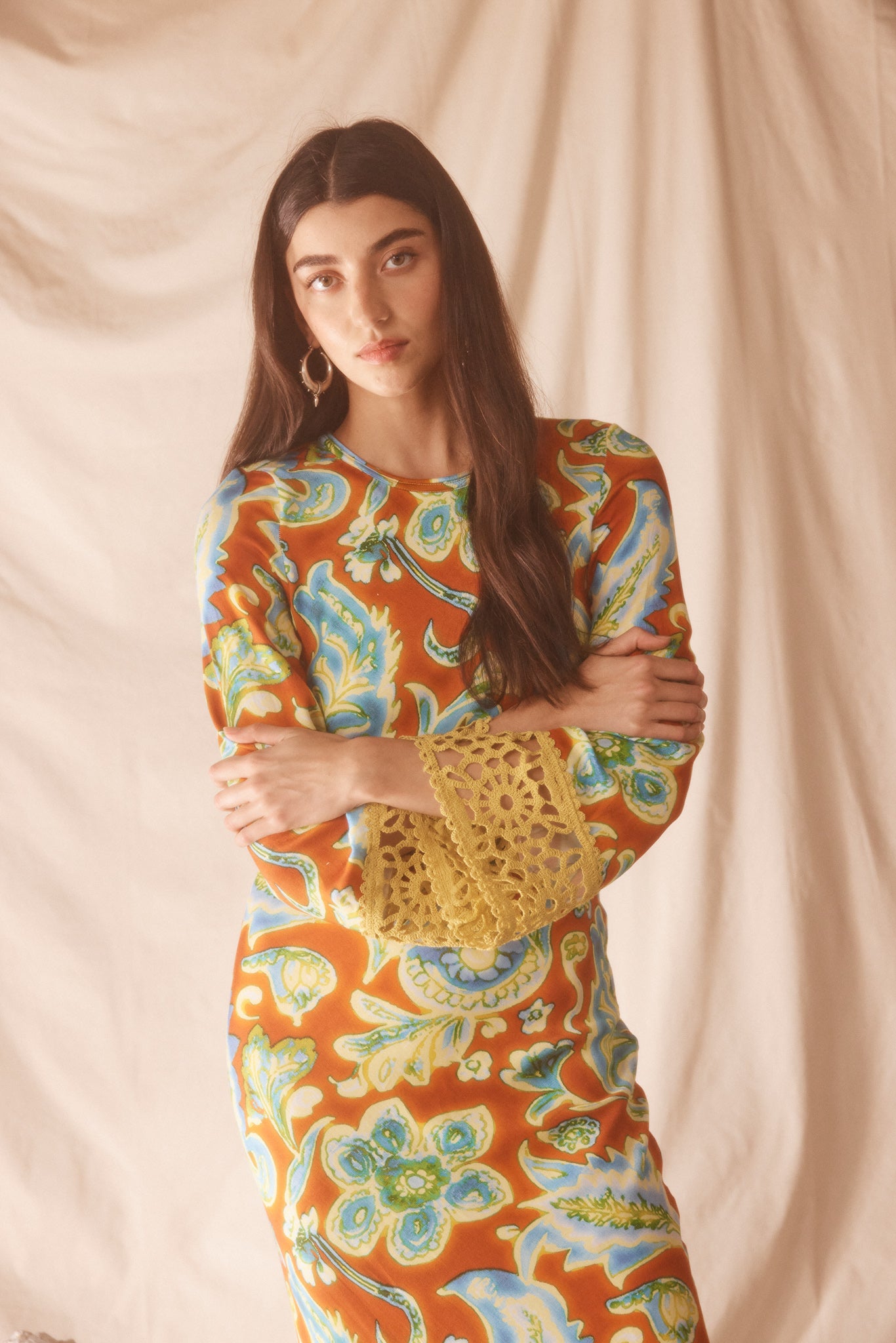 Woman wearing a colorful orange, blue and green patterned dress with lime green embroided contrast trim detail