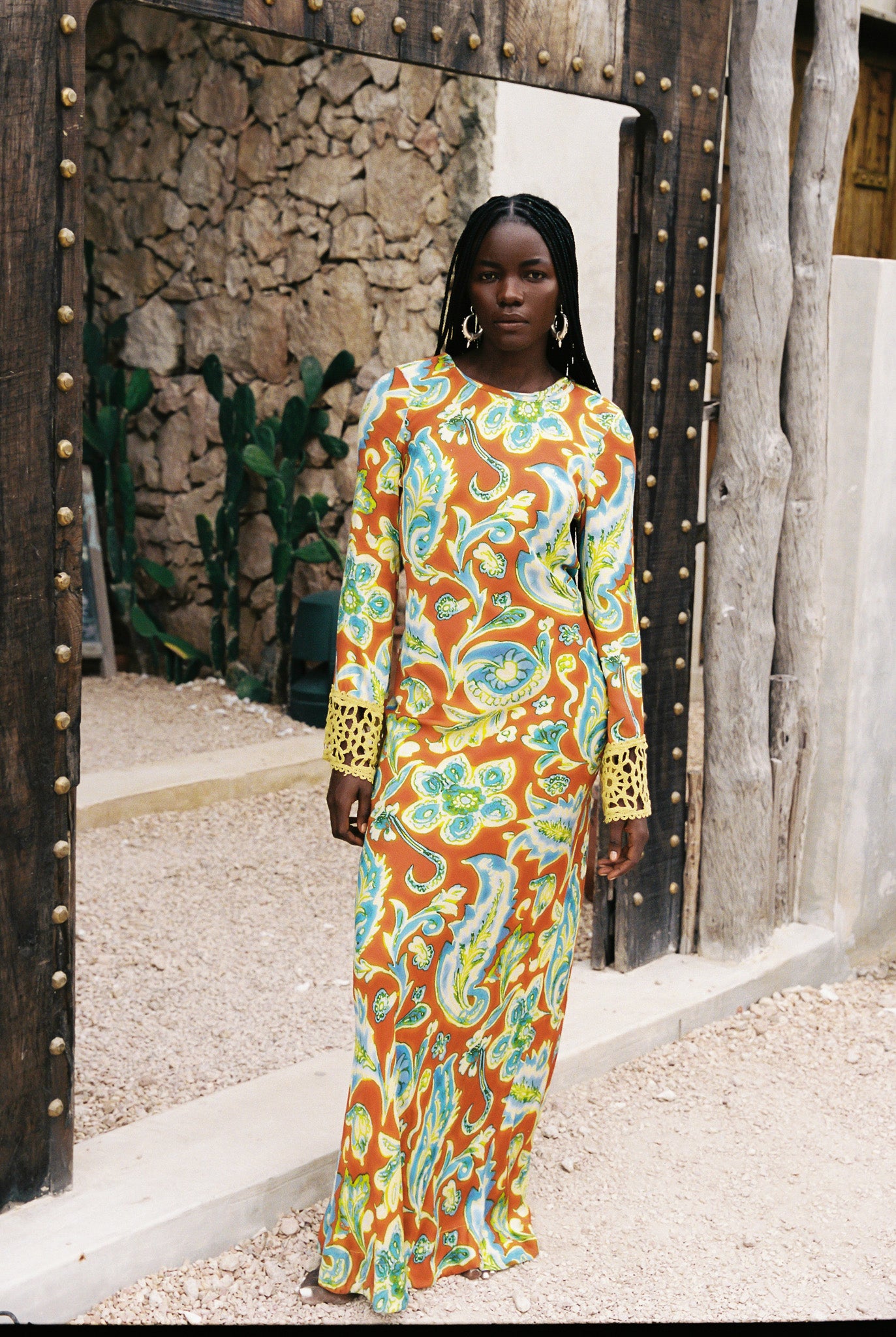 Woman wearing a colorful orange, blue and green patterned dress with lime green embroided contrast trim detail