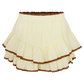 A cream yellow tiered mini skirt with brown lace hem details, displayed on a white background.