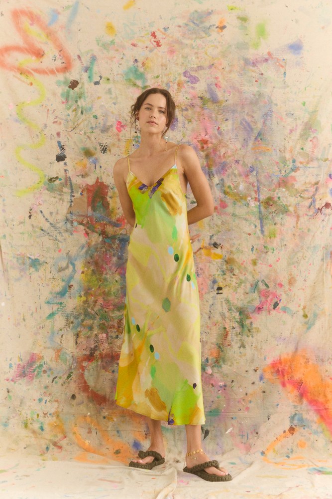 Woman in a yellow dress with colorful abstract art in the background