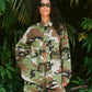 Person wearing a camouflage outfit standing in a jungle setting