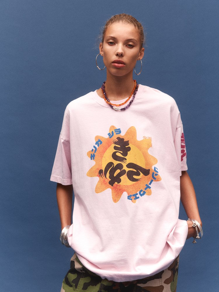 Person wearing a pink t-shirt with a colorful graphic design on a blue background