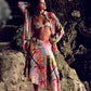 Woman in a colorful kimono and bikini standing on rocks
