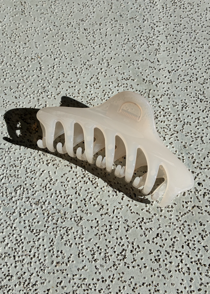 White claw clip on a textured gray surface