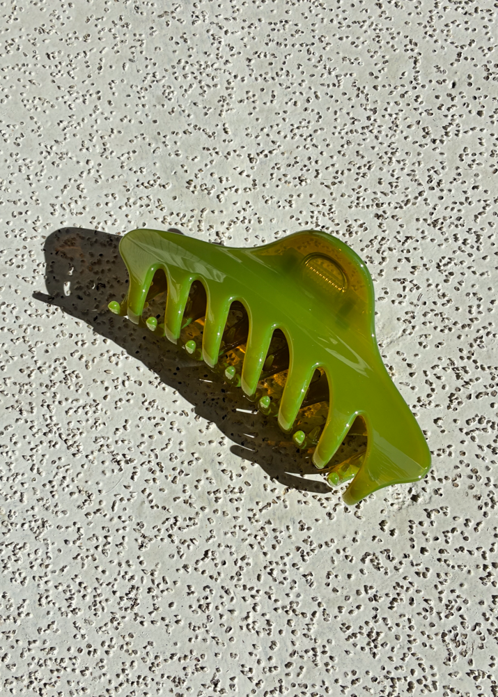 Green claw clip on a textured gray surface