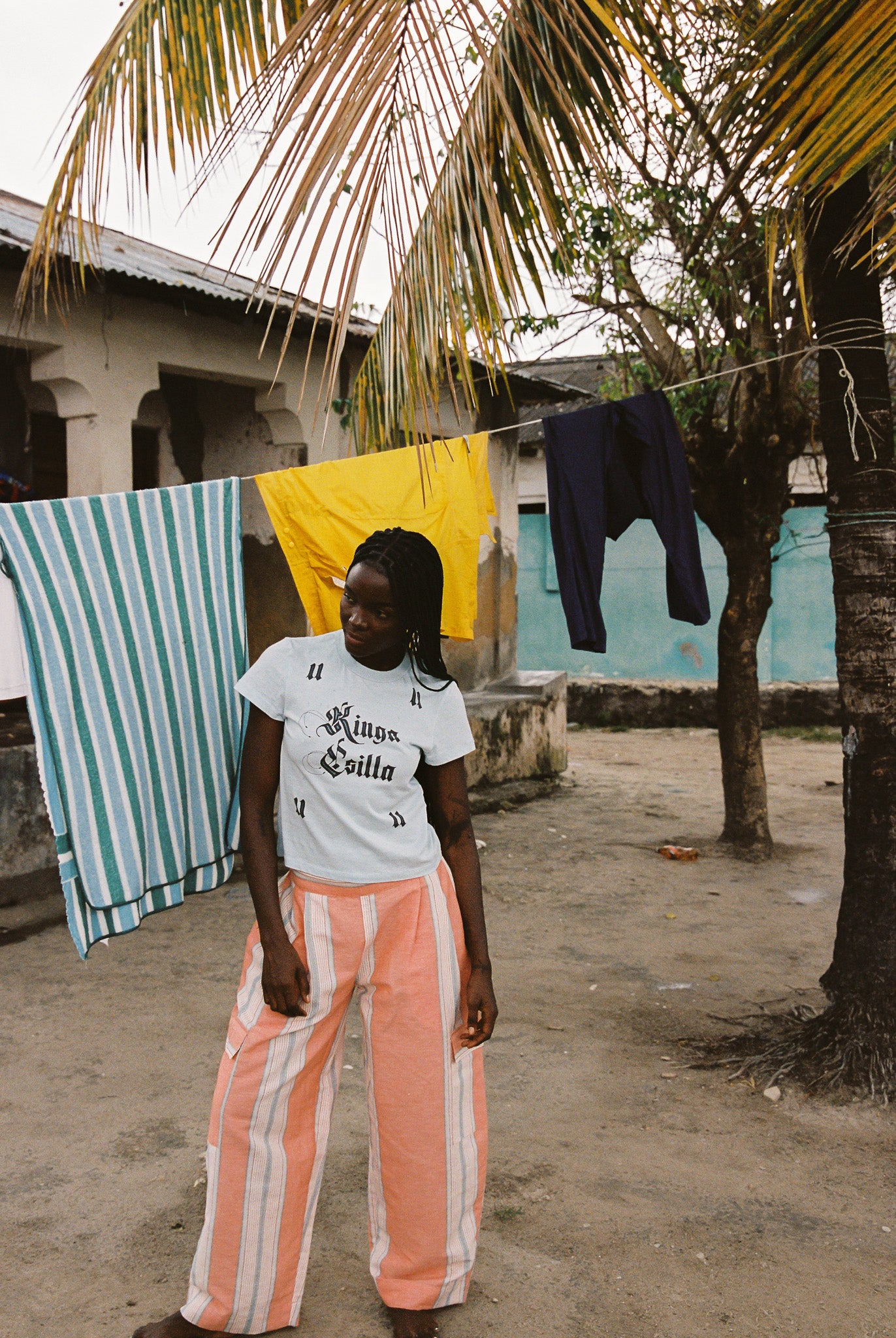 Woman wearing light blue cropped cotton tee with vintage gothic logo print, soft feel, and fitted silhouette