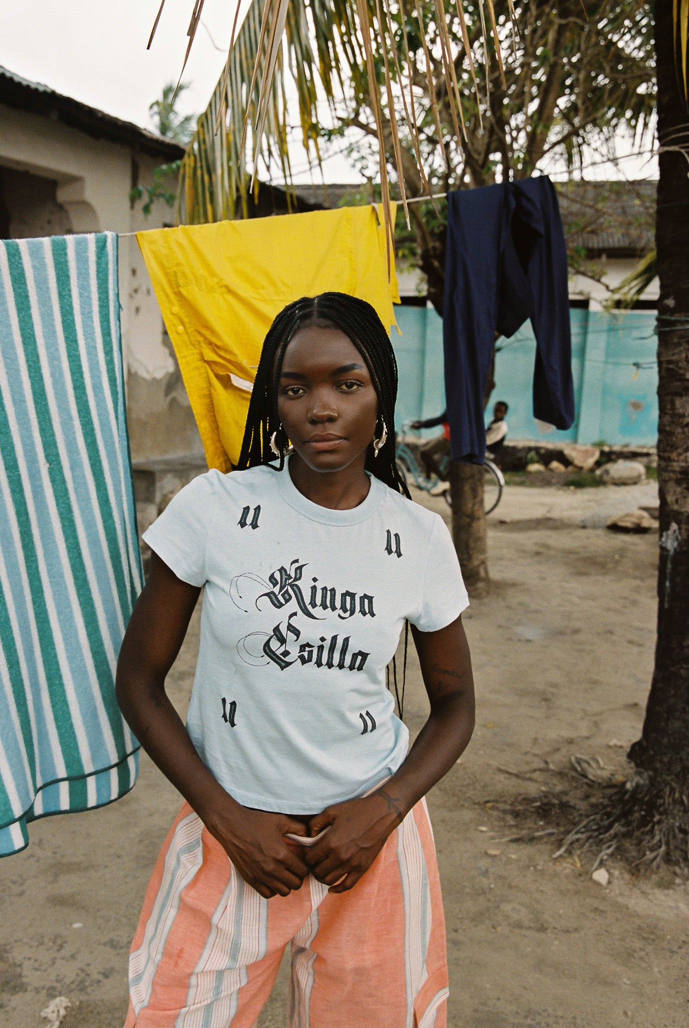 Woman wearing light blue cropped cotton tee with vintage gothic logo print, soft feel, and fitted silhouette