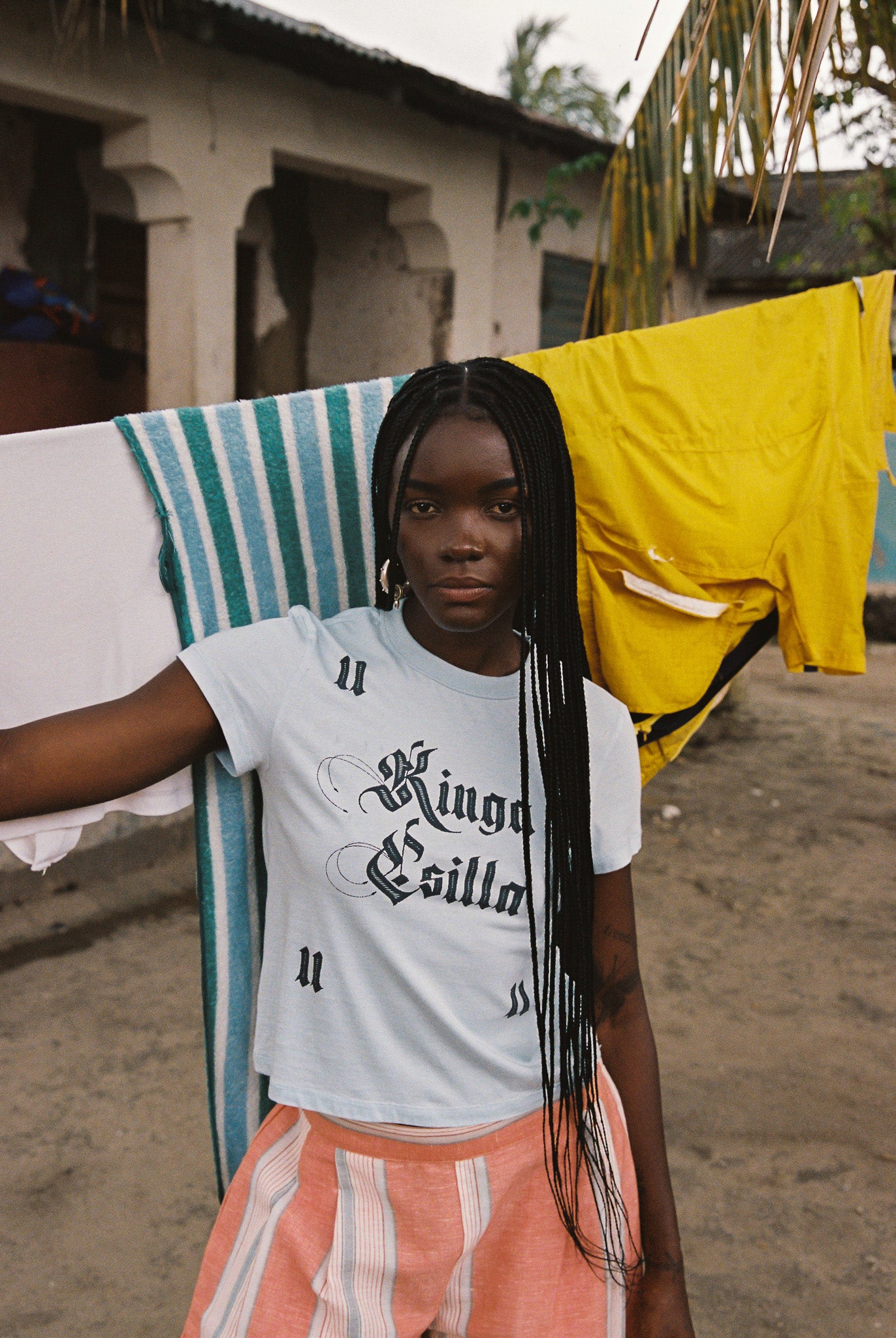 Woman wearing light blue cropped cotton tee with vintage gothic logo print, soft feel, and fitted silhouette