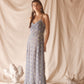 Woman wearing sheer blue sun embroidered slip with lace-trim neckline, spaghetti straps, and ethereal midi silhouette.
