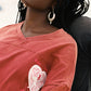 Person wearing a red  shirt dress with a pink and white graphic design on the sleeve.