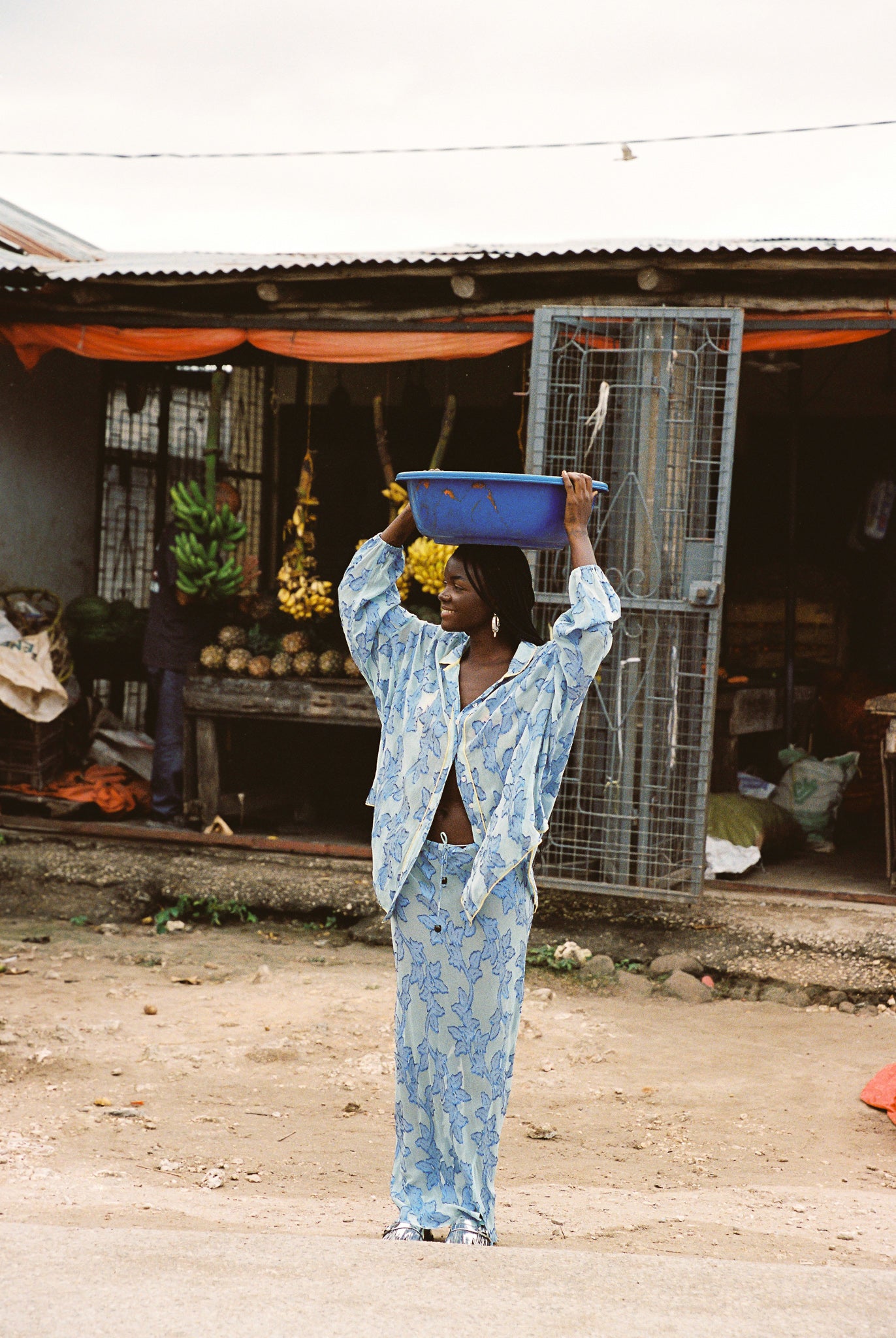 Woman wearing sheer cotton in electric blue botanical embroidery with contrast piping, curved hem, and oversized bohemian silhouette.