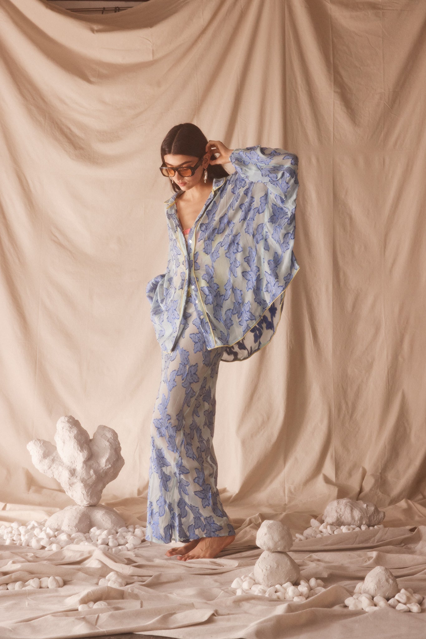 Woman wearing sheer cotton in electric blue botanical embroidery with contrast piping, curved hem, and oversized bohemian silhouette.