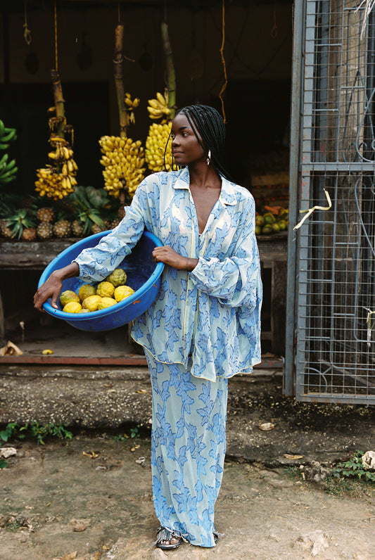 Woman in semi-sheer blue botanical embroided skirt and skirt set. 