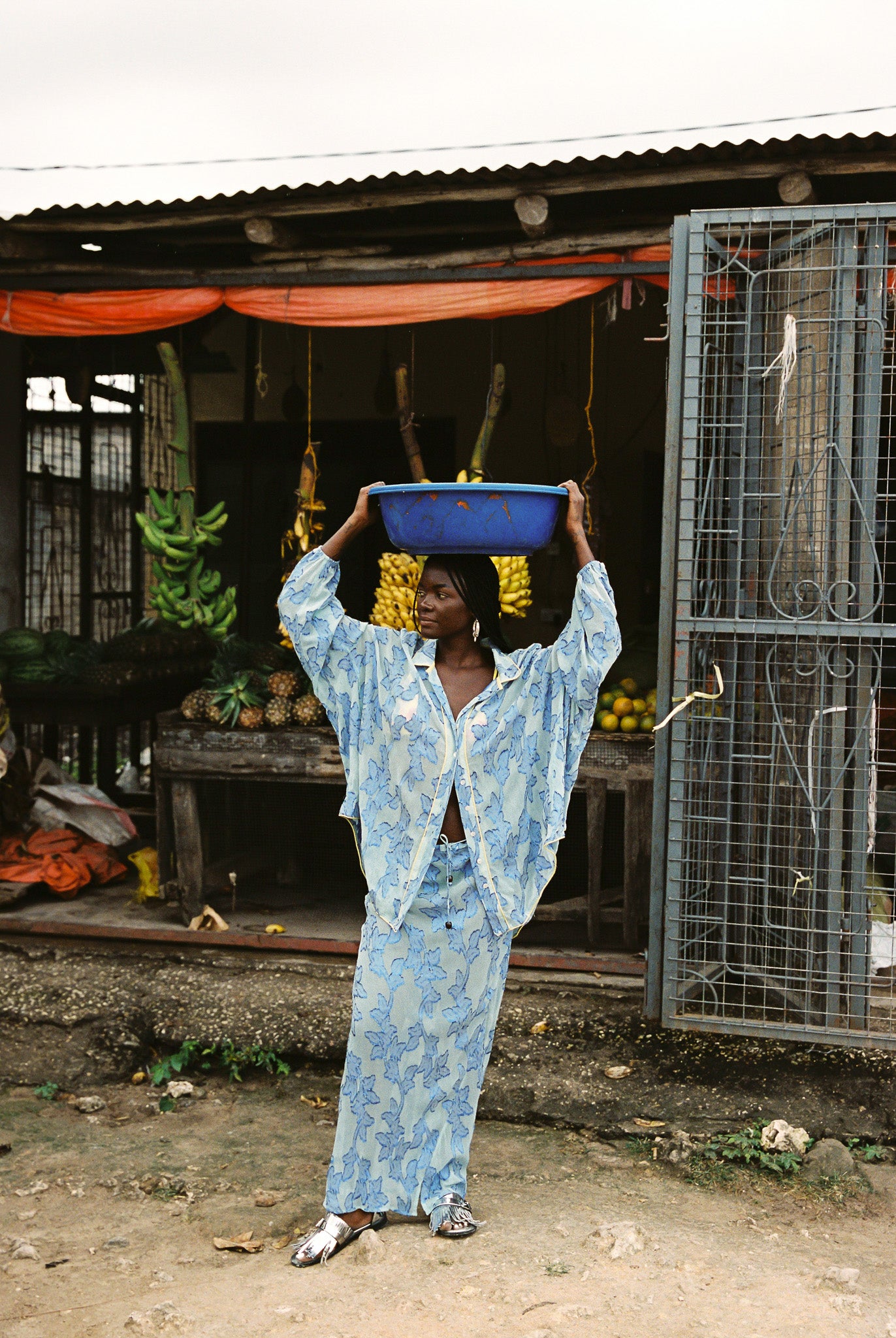 Woman wearing semi-sheer vivid blue maxi skirt with gold botanical embroidery, bias cut silhouette, and beaded drawstring waist detail.