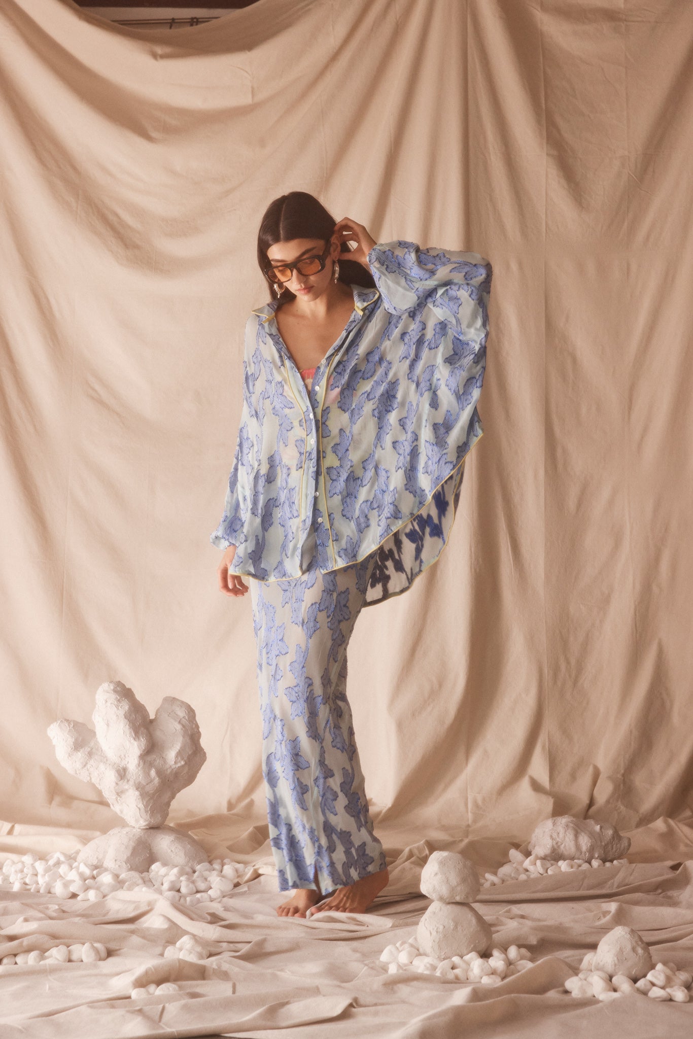 Woman wearing semi-sheer vivid blue maxi skirt with gold botanical embroidery, bias cut silhouette, and beaded drawstring waist detail.