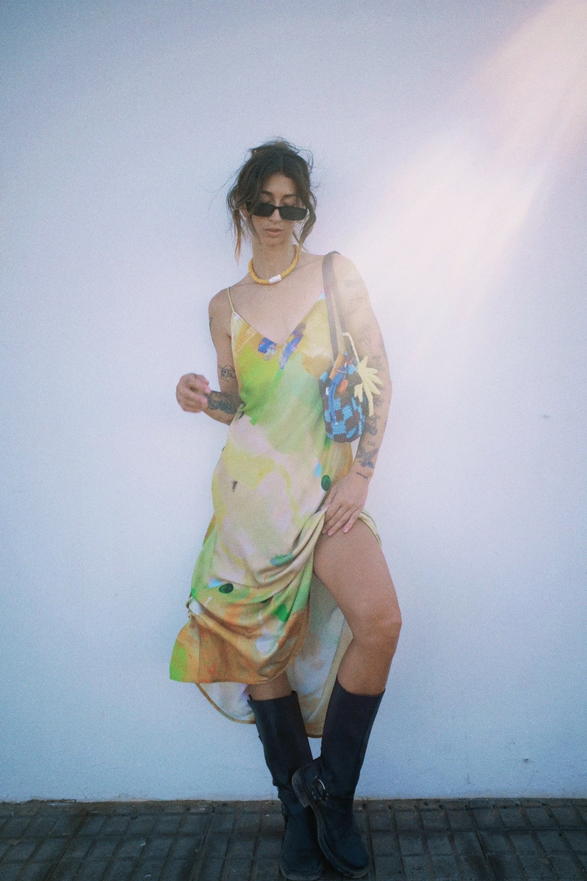 Person wearing a colorful dress with abstract design against a plain background