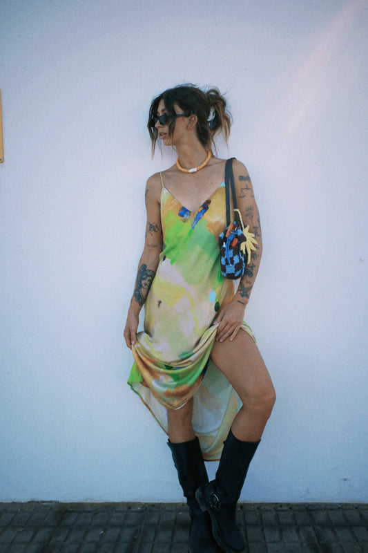 Person wearing a colorful dress with a white wall background